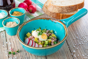 pan with salad ingredients on wooden background, close view 