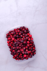 Frozen cranberries in a plastic container