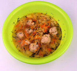 
delicious soup with balls of minced meat stands in a plate on a white background