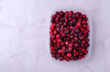 Frozen cranberries in a plastic container