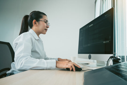 Woman asian software developers are analyzing together about the code written into the program on the computer in office room.