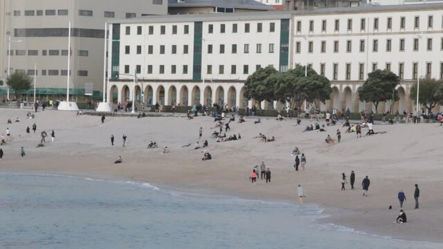 riazor beach in A Coru&ntilde;a, Spain with people strolling at sunset