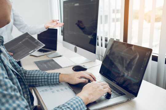 Two asian team working development of programming and encryption technology website design programmers on desk in office.