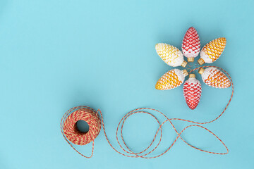Christmas toys colorful cones with craft rope on blue background. Copy space. Holiday christmas concept.