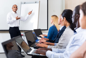 Businessman doing presentation to colleagues in front of white board