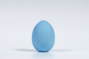 One vertical Easter egg, painted blue, is isolated on a white background with a soft shadow.