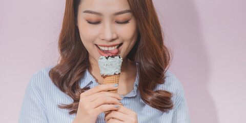 Cute young female model eating ice cream cone