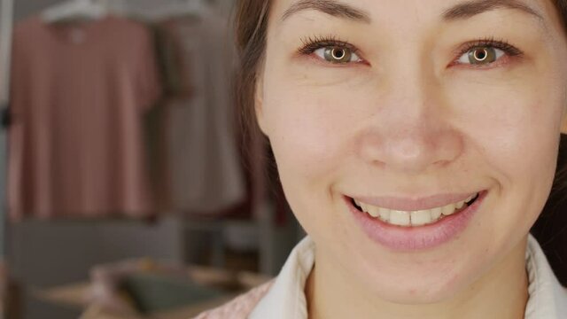 PAN close up of happy Asian woman with beautiful eyes looking at camera and smiling
