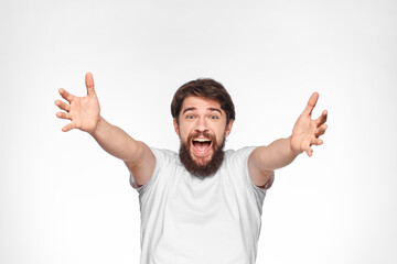 cheerful emotional bearded man gesturing with his hands close-up light background