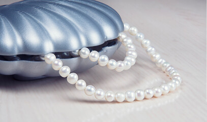 Close up of natural pearl necklace inside artificial blue seashell on pink table