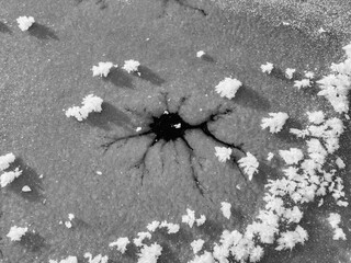 black-white patterns of snowflakes and ice crystals of air on the surface of the ice. Abstract background