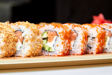 Set of various sushi rolls on a board. Close-up, selective focus