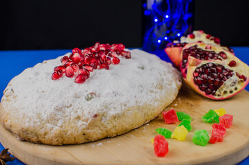 Christmas cake stolen with pomegranate on a blue background. Holiday sweets