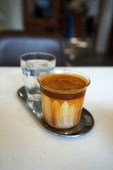 Close up glass of Latte coffee with iced water