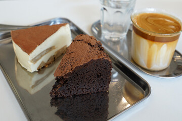 Latte coffee served with Tiramisu cake and chocolate gateau