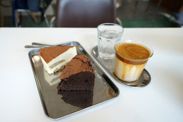 Latte coffee served with Tiramisu cake and chocolate gateau