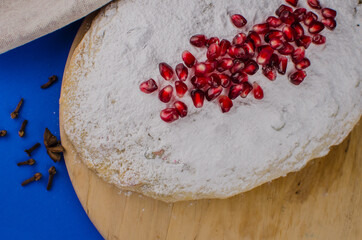 Christmas cake stolen with pomegranate on a blue background. Holiday sweets