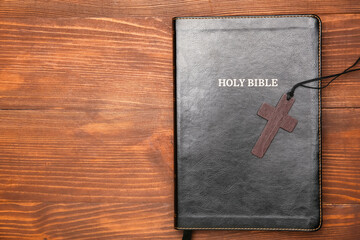 Holy Bible and cross on wooden background
