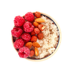 Bowl of tasty rice pudding with raspberry and nuts on white background