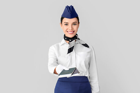Beautiful stewardess on grey background