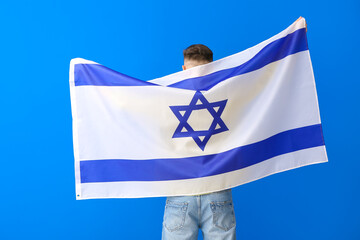 Man with the flag of Israel on color background, back view