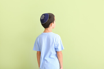 Cute Jewish boy on color background