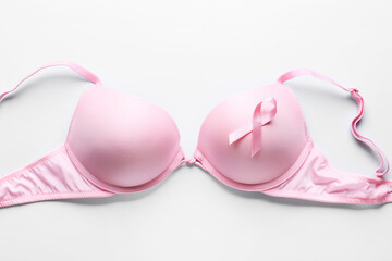 Pink ribbon and bra on light background. Breast cancer awareness concept