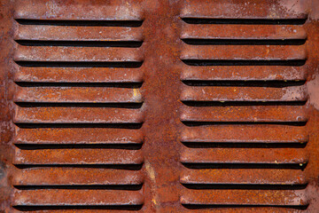 Rusty metal grilles, painted with paint and peeled off from old age, ventilation holes for air ingress in industrial facilities, an electric shield, an opening door