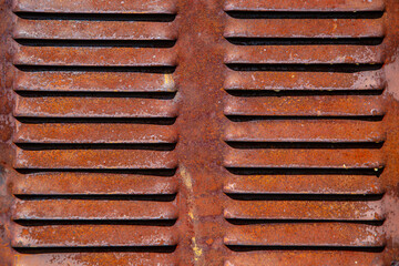Rusty metal grilles, painted with paint and peeled off from old age, ventilation holes for air ingress in industrial facilities, an electric shield, an opening door
