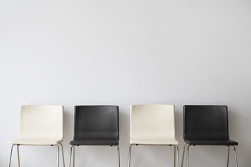 Modern chairs near light wall