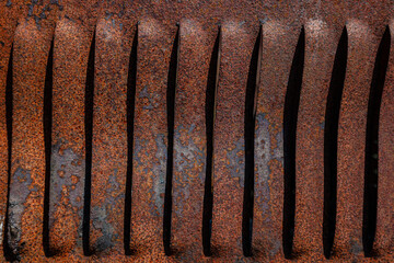 Rusty metal grilles, painted with paint and peeled off from old age, ventilation holes for air ingress in industrial facilities, an electric shield, an opening door