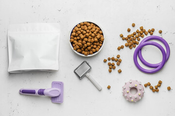 Tasty pet food and accessories on light background