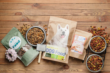 Tasty pet food and accessories on wooden background