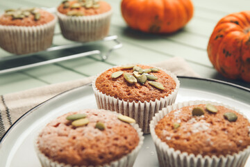 Plate with tasty pumpkin muffins on table, closeup