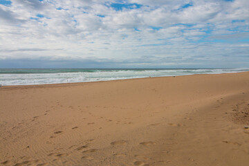 Footprints in Sand on Beach Leading Down to Ocean Waves