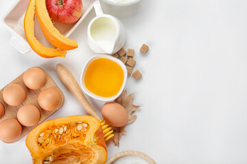 Ingredients for preparing pumpkin pie on white background