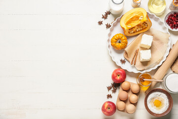 Ingredients for preparing pumpkin pie on white wooden background