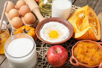 Ingredients for preparing pumpkin pie on wooden background
