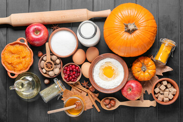 Ingredients for preparing pumpkin pie on dark wooden background