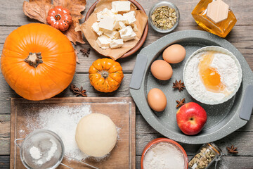Ingredients for preparing pumpkin pie on wooden background