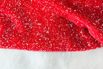 Texture of Santa Claus hat in the snow. Red background.