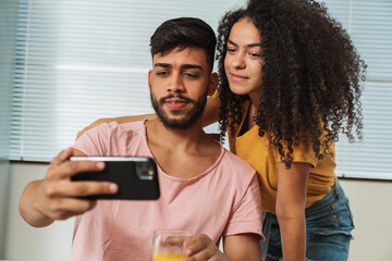 Young adult latin american couple looking at cellphone