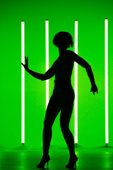 Sports young woman dancer performing solo in the studio on a colorful background with neon lighting tube. Dance color poster.