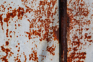 On a rough wall or floor, paint flakes off. Corrosion and rust of metal. Old dilapidated wall.