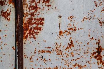 On a rough wall or floor, paint flakes off. Corrosion and rust of metal. Old dilapidated wall.