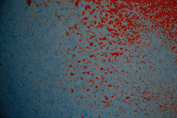 On a rough wall or floor, paint flakes off. Corrosion and rust of metal. Old dilapidated wall.