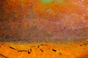 On a rough wall or floor, paint flakes off. Corrosion and rust of metal. Old dilapidated wall.