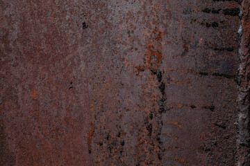 On a rough wall or floor, paint flakes off. Corrosion and rust of metal. Old dilapidated wall.