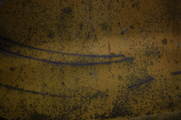 On a rough wall or floor, paint flakes off. Corrosion and rust of metal. Old dilapidated wall.