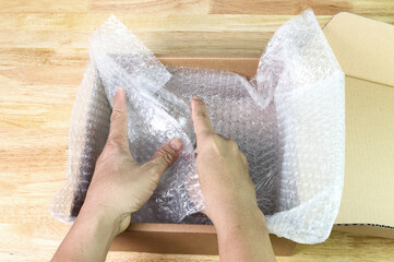 hand of man hold bubble wrap cover glass for protection product cracked or insurance During transit